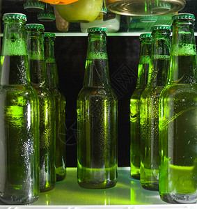 冰箱里架子上的绿色啤酒瓶玻图片