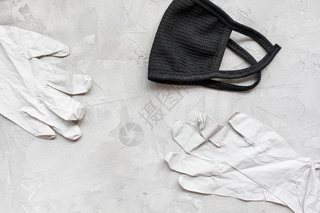 灰色背景的可洗黑棉口罩和医用橡胶手套CoronaCovid19防图片