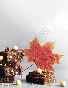 堆满了巧克力片和栗子和叶子在灰色的桌子上图片