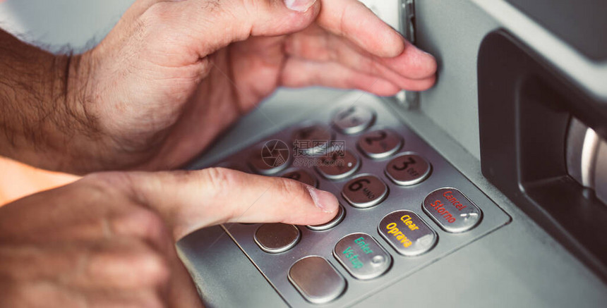 在自动取款机上输入信用卡密码的人撤回钱财图片