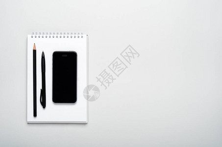 智能手机铅笔灰色背景记事本上的钢笔图片