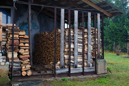 木柴的原木堆在石板屋顶下炉子加热的燃料乡村生活木柴堆砌的墙天然木材背景背景图片