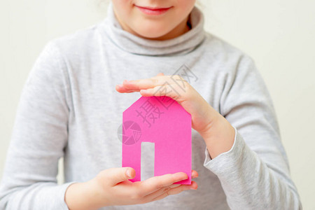 小女孩手里拿着玩具纸粉红色的房子图片