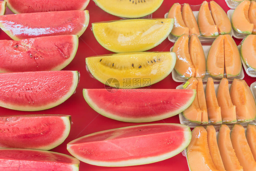 新加坡市场摊位上用保鲜膜保鲜膜包裹着红色黄色西瓜和哈密瓜的五颜六色的新鲜切片方便携带或图片