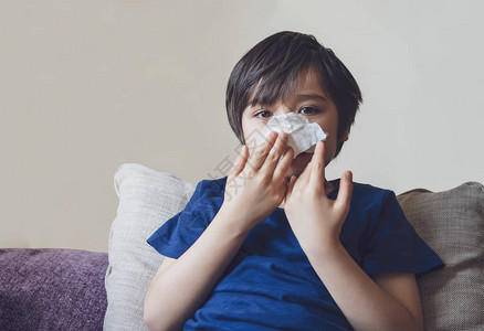 皮肤干燥不健康的孩子把鼻子吹进纸巾里图片