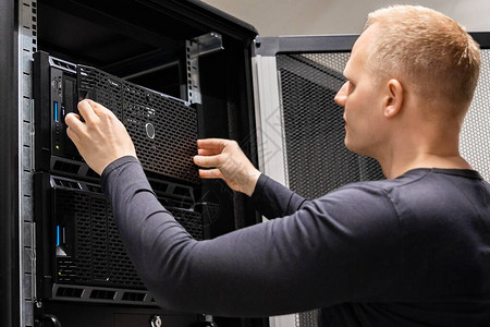 自信的男技术员在企业数据中心安装服务器用于云宿托管服务图片