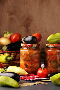 木桌上玻璃罐中的茄子辣椒洋葱和西红柿蔬菜沙拉图片