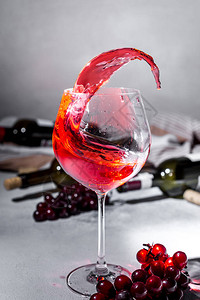红葡萄酒瓶子和一杯红葡萄酒以及成熟的葡萄用文背景图片