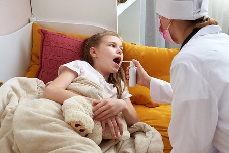 儿科医生检查一个生病的小女孩的喉咙孩子看起来生病和悲伤医生在家看图片