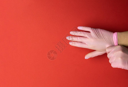 用防菌清扫剂凝胶在实验室手套中以医疗红色背景使用抗菌素图片
