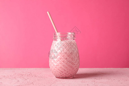 粉红色背景的草莓罐甜饮料图片