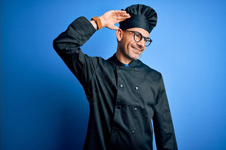 年轻英俊的厨师穿着炊具制服和帽子图片