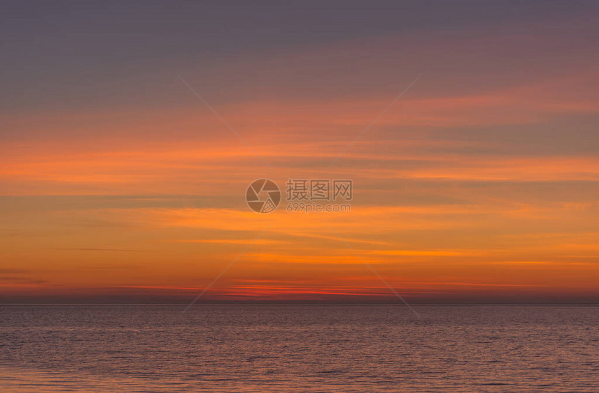 明亮的暮色日落天空在海面上日落后橙色调的美妙天空自然背景海洋和天空的紫色调图片