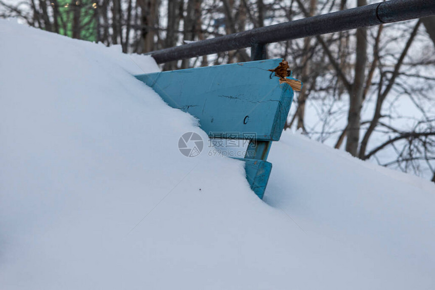 长椅的角从雪中伸出来在遥远的北图片