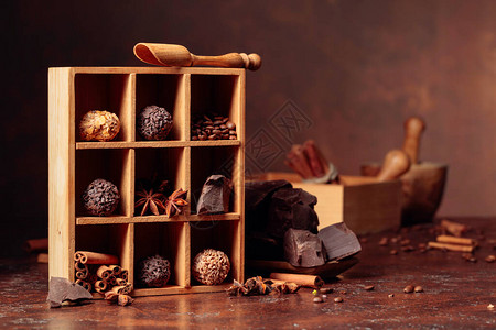 松露巧克力碎块巧克力和香料木盒中的巧克力肉桂条茴香和咖啡豆复图片