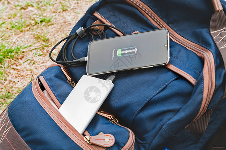 现代智能手机在徒步旅行时躺在背包上图片