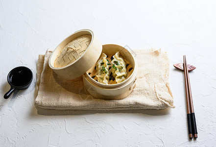 小吃蒸饺木制蒸笼饺子小吃亚麻布上的传统美食图片