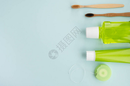浅蓝色背景的竹布牙刷和口腔卫生产品牙科卫生概念顶视平板便图片