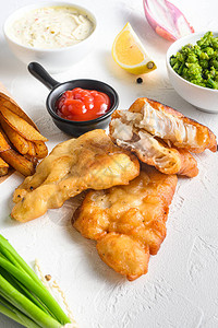 鱼和薯条用蘸酱和柠檬在白色背景的纸锥中涂上酥脆的鳕鱼片细节图片