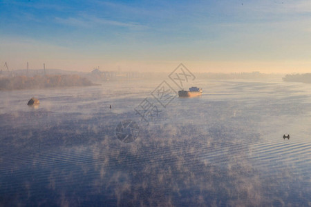 工业船在清晨雾中沿着河图片