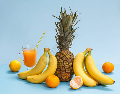 来自热带水果的天然成分新鲜的菠萝香蕉橘子和柠檬和一杯蓝图片