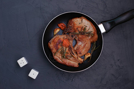 黑底煎锅里烤猪肉排在最顶级视野图片