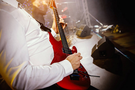 吉他手在演唱台上弹吉他用红色吉他图片