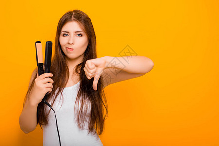 一位年轻女子用直发器拉直她的头发热直发器对头图片