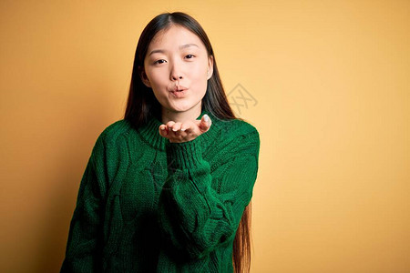 年轻美丽的亚洲女人穿着绿色的冬季毛衣图片