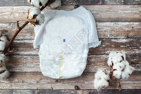 婴儿尿布软化如棉花躺在木质背景上图片