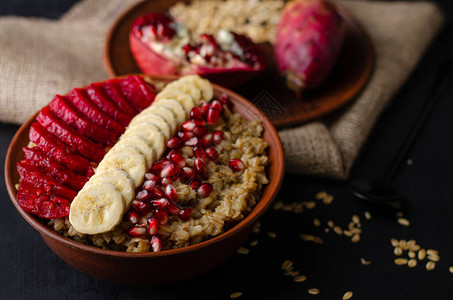 健康饮食早餐概念用香蕉石榴种子和甘蓝仙人掌水果的燕麦图片