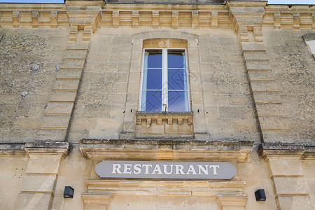 街上旧法国大楼窗户的餐厅文字牌背景图片