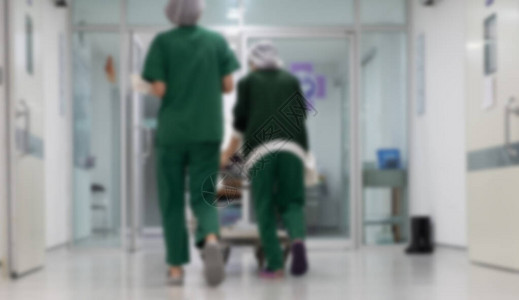 的模糊图像将担架上的病人推过医院走廊到急诊室图片