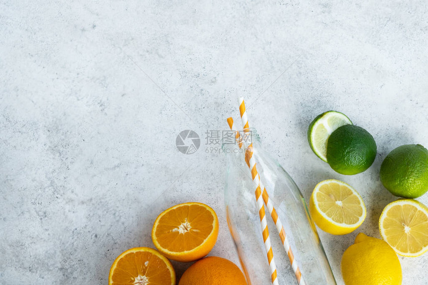 柑橘类水果和玻璃瓶在浅色背景制作夏季饮品的原料健康饮食维生素C免疫系统助推器顶视图平图片