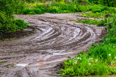 带水坑和轮胎足迹的泥土路Zigzag转弯背景图片