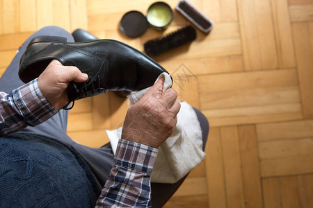 男人用抹布和鞋蜡毛巾洗鞋的手他的图片