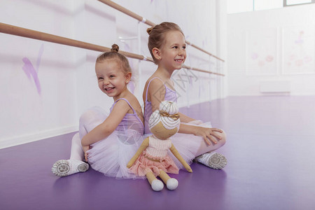 可爱的小芭蕾舞演员在芭蕾舞课上跳舞后放松图片