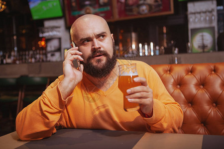 成熟男人在酒吧喝啤酒时在图片