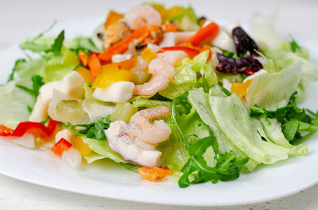 海产食品沙拉和蔬菜及白盘上的生菜图片