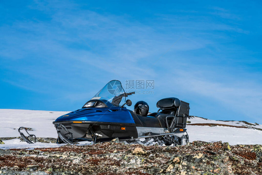一辆蓝色的摩托在挪威山区的上高地站立着石头图片