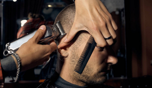 理发师在理发店剪了一个人短发和头发轮廓对齐关闭客户的肖背景图片