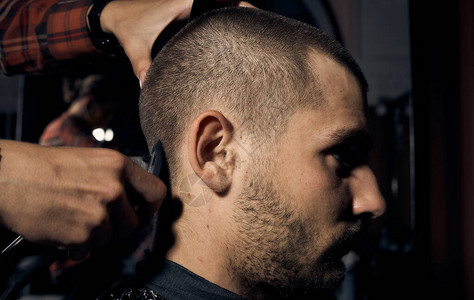 理发师在理发店剪了一个人短发和头发轮廓对齐关闭客户的肖背景图片