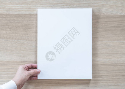 空白A4尺寸书籍封面样机模板顶视图在商人手中图片