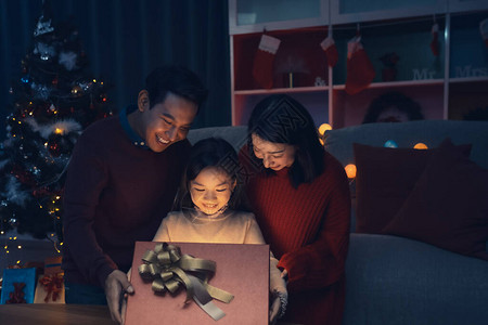 幸福的家庭和小女孩打开魔法礼盒图片
