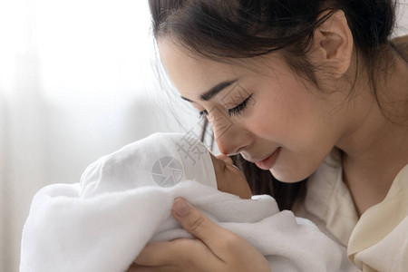 亲吻她可爱的新生婴儿妻子和母亲的一天概念图片