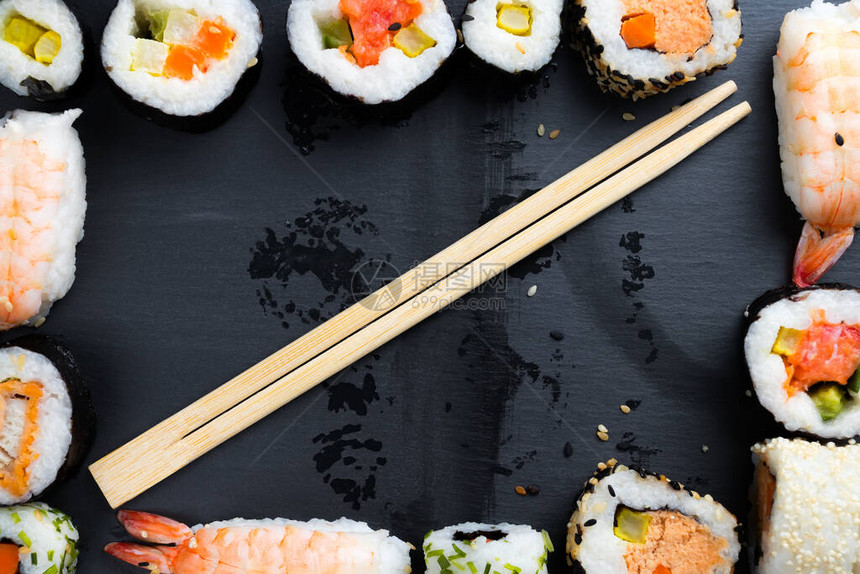 黑厨房板块上的日本寿司和筷子图片