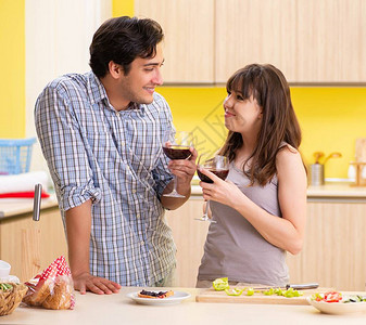 年轻夫妇在厨房庆祝结婚纪念背景图片