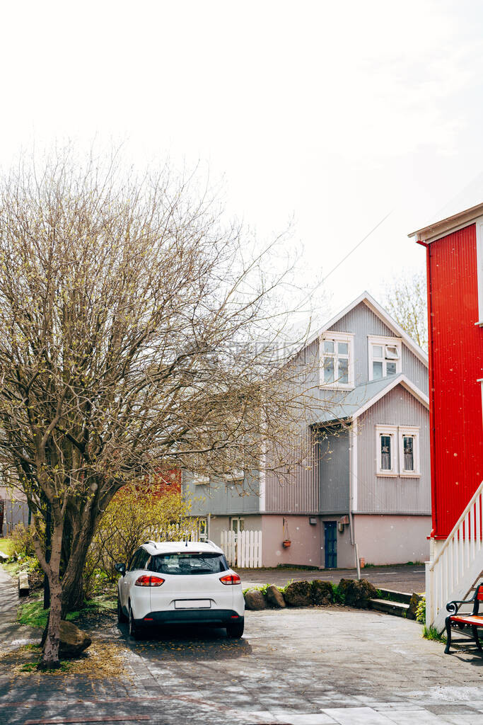白色汽车停在冰岛首都雷克雅未克街上房子外的白车图片