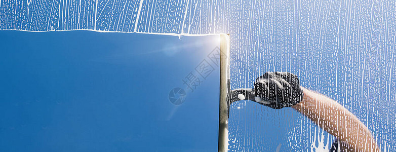 窗户清洁剂用泡沫和拉手清洁窗户图片