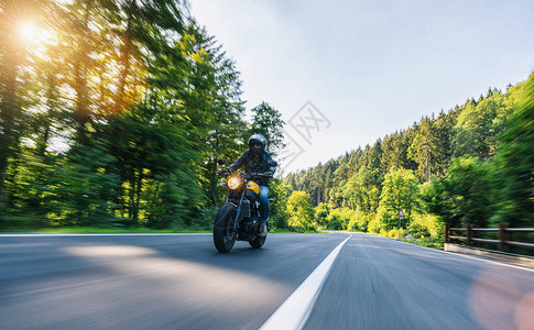高山公路上骑摩托车在摩托车之旅中驾驶空荡的道路玩得开心个人文图片